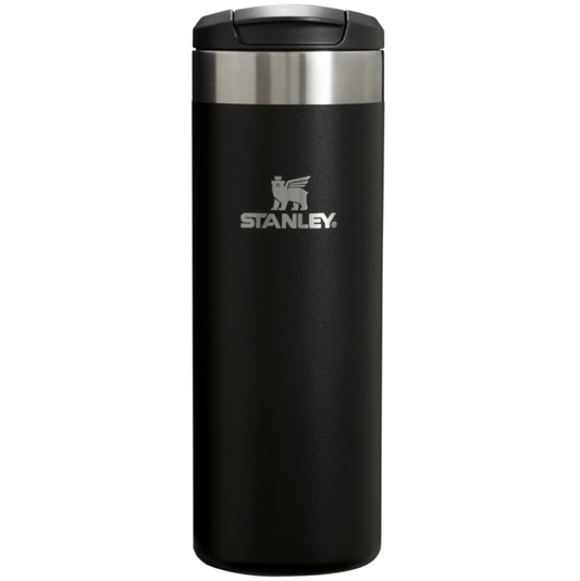 A black Stanley travel tumbler with a stainless steel band and a silver logo on the front, shown against a plain white background.